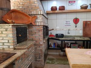 a kitchen with a brick oven with a fish on it at Pousada Sonho Meu Foz in Foz do Iguaçu +76 photos