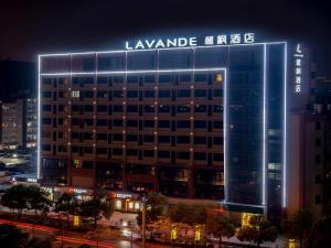 un grand bâtiment avec un panneau éclairé dans l'établissement Lavande Hotels·Foshan Zhoucun Ligang Road Xunfenggang Metro Station, à Foshan