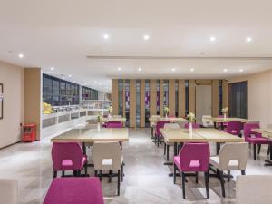 une salle à manger avec des tables et des chaises violettes dans l'établissement Lavande Hotels·Foshan Zhoucun Ligang Road Xunfenggang Metro Station, à Foshan