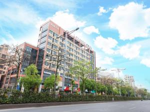 ein hohes Gebäude mit Straßenlicht davor in der Unterkunft Lavande Hotels·Foshan Zhoucun Ligang Road Xunfenggang Metro Station in Foshan