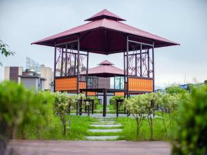 a gazebo with a table and umbrella in a park at Lavande Hotel Chongqing West Station Baguo Cheng in Chongqing