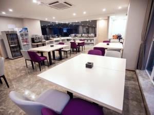 a restaurant with white tables and purple chairs at Lavande Hotel Chongqing West Station Baguo Cheng in Chongqing