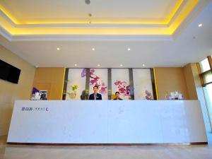 two people standing behind a counter in a room at Lavande Hotels·Guangzhou Luoxi Xiajiao Metro Station in Guangzhou