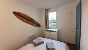 ein Schlafzimmer mit einem Bett mit einem hölzernen Kanu an der Wand in der Unterkunft Vacances Ô Cap Coz - Jardin vue mer et piscine - Résidence Cap Azur Fouesnant in Fouesnant + 62 Fotos