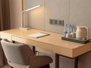 a desk with a lamp and two bottles of water at Lavande Hotels·Foshan Yanbu Suiyan East Road in Foshan