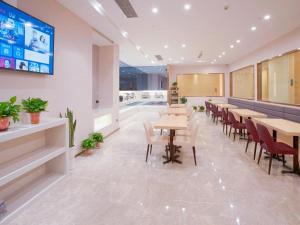 南京市にあるLavande Hotels·Nanjing South of Olympic Stadium Daishan New Townのテーブルと椅子のあるレストラン、プールを提供しています。