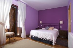 um quarto roxo com uma cama e uma cadeira em Casa Rural Enkartada em Sopuerta