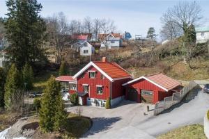 ein rotes Haus mit rotem Dach auf einem Hügel in der Unterkunft Nyrenoverat källarlägenhet in Ljungskile