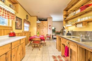 a kitchen with wooden cabinets and a table with chairs at La Crescent Cottage on Minnesota Bluffs with View! in La Crescent