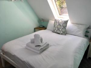 a white bed with towels on it with a window at The Annex, Manor Road, Didcot in Didcot
