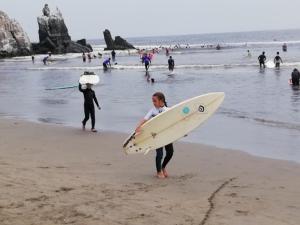 塞鲁阿苏尔蓝山海滩度假屋的一名在海滩上拥有冲浪板的女人