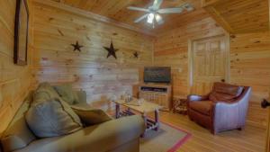 a living room with a couch and a tv in a cabin at Heavens Whisper in Blue Ridge
