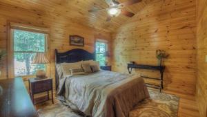 ein Schlafzimmer mit einem Bett in einer Blockhütte in der Unterkunft High Five Lodge in Mineral Bluff