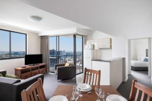 a living room with a kitchen and a living room with a table at Mantra on Queen in Brisbane