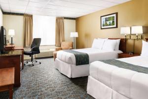 a hotel room with two beds and a desk at Lakeview Golf Resort in Morgantown