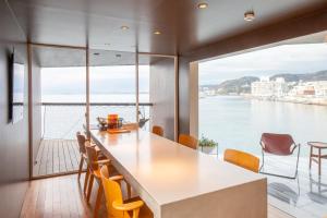 a kitchen with a table and chairs and a view of the water at 佐島 - Nowhere but Sajima - ペット可 in Yokosuka