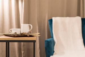 a table with two coffee cups and a chair at Rías Altas - Hotel Restaurante in Barreiros