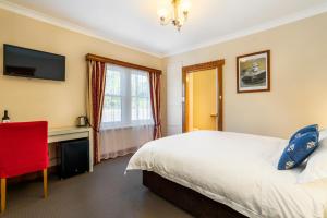 a bedroom with a bed and a desk and a television at Ashdowns of Dover in Dover