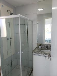 y baño con ducha acristalada y lavamanos. en Flat em Muro Alto- Porto de Galinhas, en Porto de Galinhas