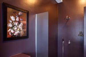 a bathroom with a painting of flowers on the wall at Blue Tulip Amsterdam in Amsterdam
