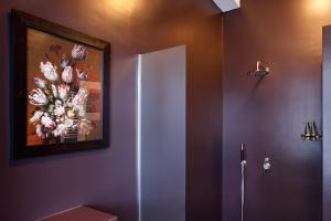 un baño con una pintura de flores en la pared en Blue Tulip Amsterdam en Ámsterdam