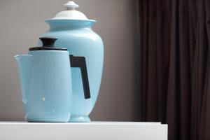 a blue vase and a bottle on a shelf at Blue Tulip Amsterdam in Amsterdam