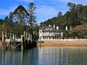 a large house on the shore of a body of water at Beachside at Snells - Snells Beach Apartment in Snells Beach