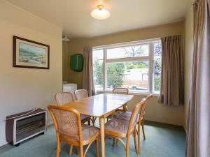 a dining room with a table and chairs and a window at Arrow Bach - Arrowtown Holiday Home in Arrowtown