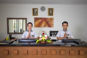 two men in uniforms are sitting at a desk at Danoya Private Luxury Residences in Seminyak