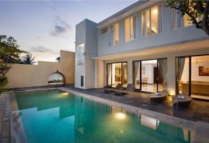 una casa con piscina frente a una casa en Danoya Private Luxury Residences, en Seminyak