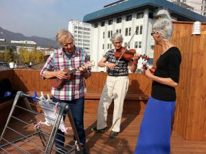a group of people playing music on a deck at Insadong Hostel in Seoul