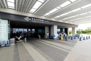 un edificio con gente sentada en sillas delante de él en Re-Rent Residence 押上, en Tokio