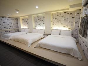 2 camas sentadas en un banco en una habitación en 合悅都會商旅 Heyue HOTEL en Hsinchu City