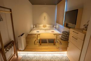 a small bedroom with a bed and a table at GEN HOTEL KAMAKURA in Kamakura