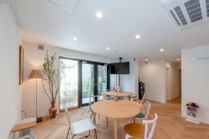 a dining room with a wooden table and chairs at plat hostel keikyu haneda home in Tokyo