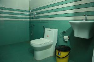 een badkamer met een toilet en een wastafel bij Marari Baiju's Homestay in Mararikulam