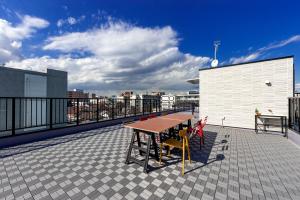 a table and chairs on the roof of a building at plat hostel keikyu haneda home in Tokyo