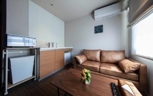 a living room with a couch and a table at GRAND BASE Kurashiki Chuo in Kurashiki