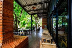 um restaurante com bancos e mesas num deque em วันสุขรีสอร์ทสุโขทัย em Ban Khlong Takhian