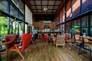 un ristorante con sedie e tavoli e un bar di วันสุขรีสอร์ทสุโขทัย a Ban Khlong Takhian