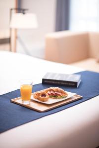 a plate with a sandwich and a glass of orange juice at Hotel Sirius in Jeju