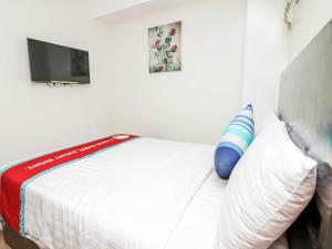 um quarto de hotel com uma cama com uma almofada e uma televisão em The Orient Beach Boracay em Boracay