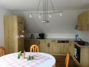 una cucina con tavolo e una cucina con armadietti in legno di Ferienwohnung Martina a Sinzing
