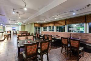 a restaurant with tables and chairs and a brick wall at Holiday Inn & Suites San Mateo - SFO, an IHG Hotel in San Mateo