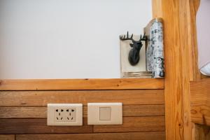 a wooden shelf with a light switch and books at QBE B&B in Nanwan