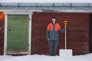 a man standing in the snow next to a building at Arthotel Tornedalen in Risudden