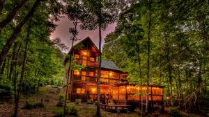Una gran casa de madera en el bosque por la noche. en Our Blue Heaven, en Blue Ridge