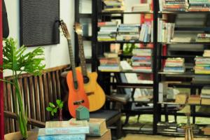 a guitar sitting on a chair in a room with books at Domino Homestay in Ho Chi Minh City