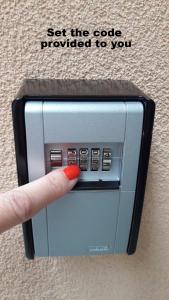 una persona con una uña roja pulsando un botón en un microondas en VIP Apartments Sofia, en Sofía