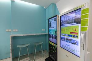eine Bar mit zwei Hockern neben einem Computerbildschirm in der Unterkunft Philip Hotel in Singapur
